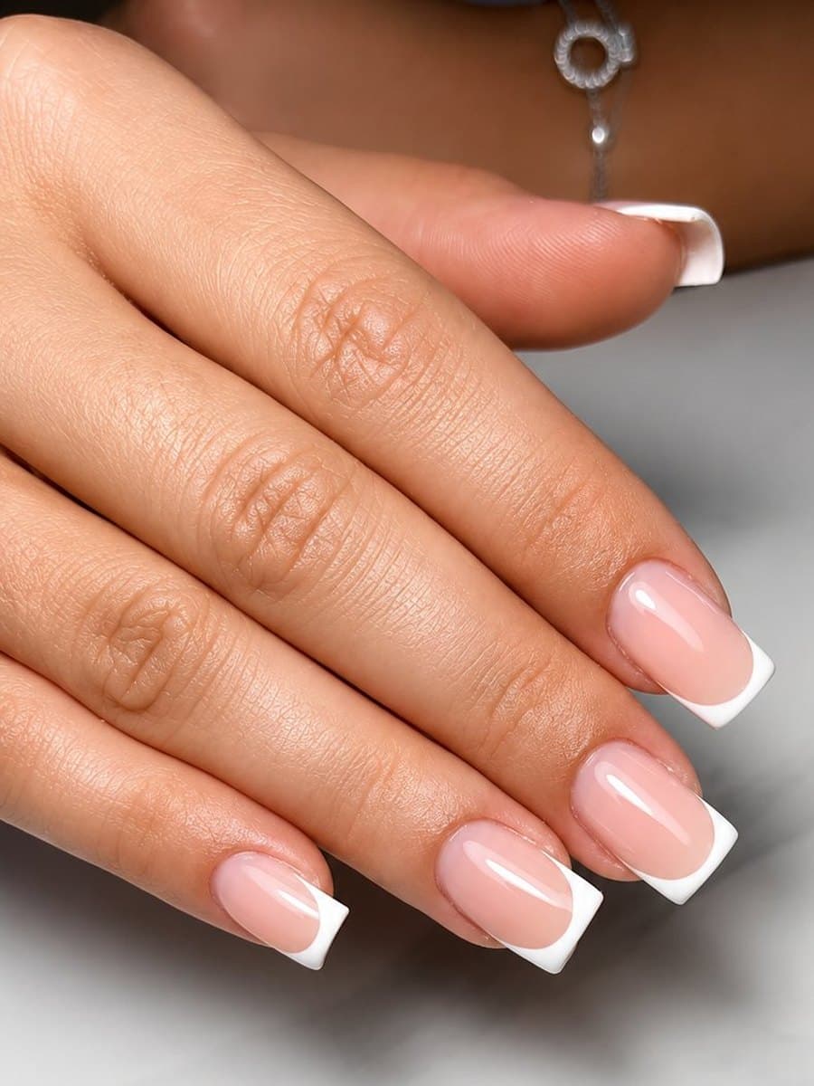 French blanche sur ongles carrés courts, sourire fin et régulier sur base rosée