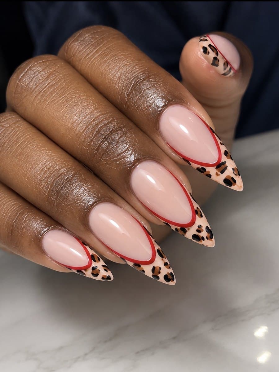 Ongles stiletto nude à pointes léopard beige et noir, séparées de la base par un fin liseré rouge