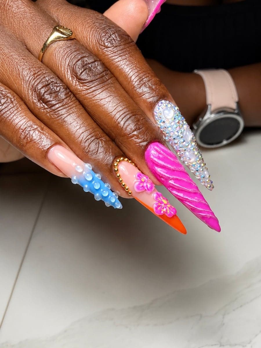 Ongles stiletto colorés : torsade rose sculptée, ongle serti de strass et de perles, bulles bleues en relief